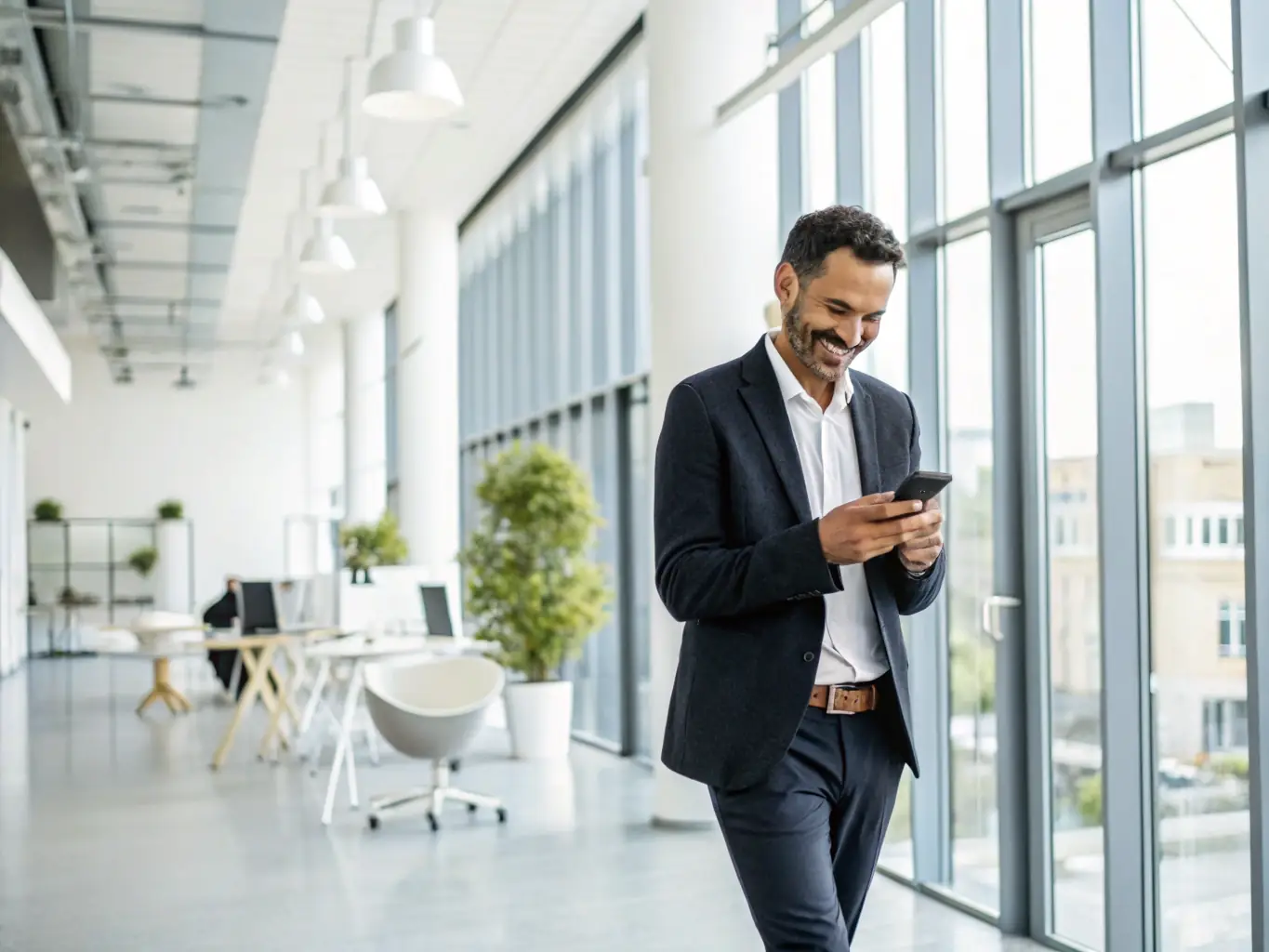 A real estate agent walking through an office, using voice commands to send a thank-you message to a client after a successful meeting. The image emphasizes the ease of maintaining client relationships.